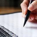 Mão escrevendo em um bloco de notas